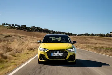 Vista dinámica del Audi A1 en carretera, destacando su diseño frontal y perfil lateral.