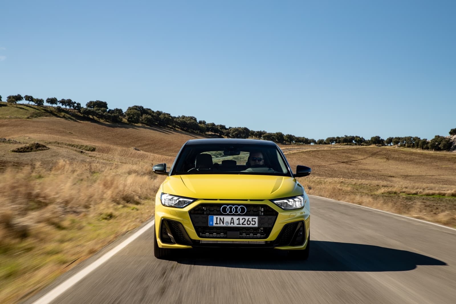 Vista dinámica del Audi A1 en carretera, destacando su diseño frontal y perfil lateral.