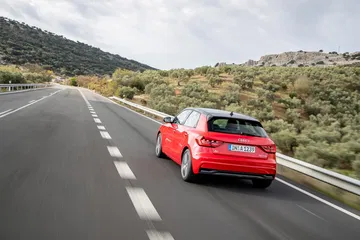 Vista dinámica del Audi A1 en carretera, destacando su diseño trasero y lateral.