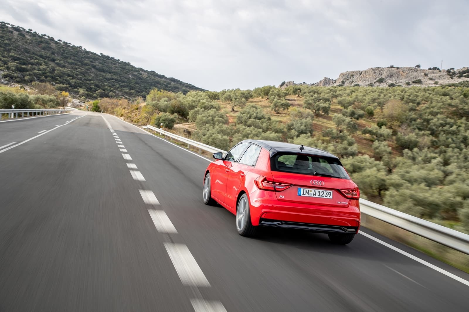 Vista dinámica del Audi A1 en carretera, destacando su diseño trasero y lateral.