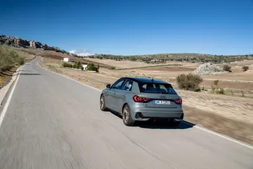 Vista dinámica trasera y lateral del Audi A1 en carretera abierta.