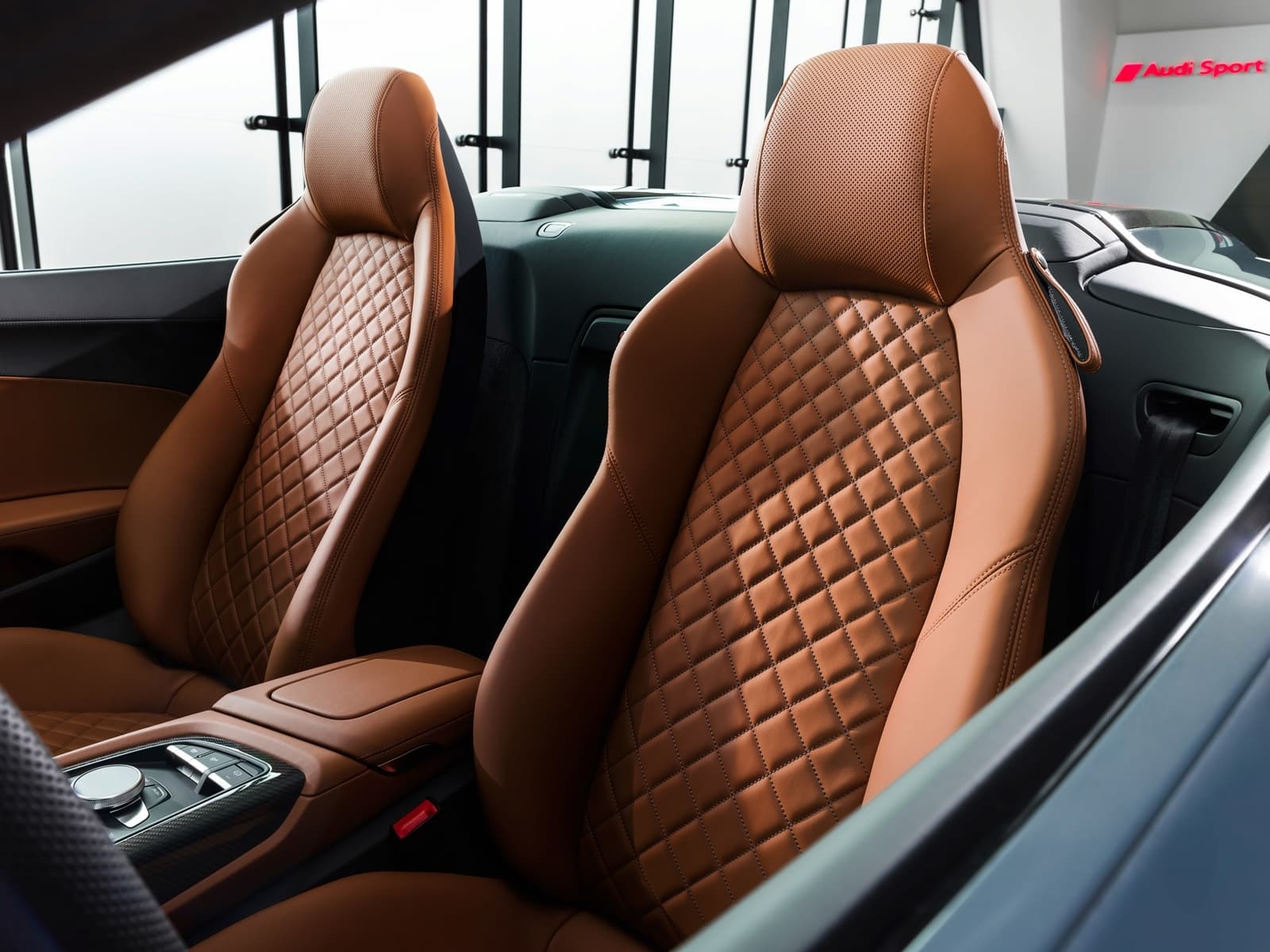 Asientos deportivos marrones en cuero con patrón de rombos.