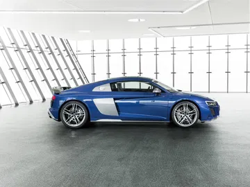 Vista lateral del Audi R8 en tono azul metálico, destacando su línea aerodinámica.