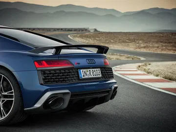 Vista dinámica de la trasera y lateral del Audi R8 en carretera.