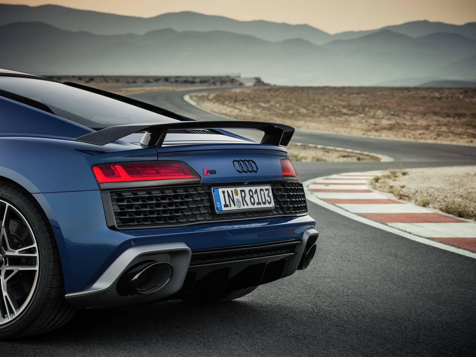 Vista dinámica de la trasera y lateral del Audi R8 en carretera.