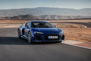 El Audi R8 domina el asfalto con su diseño lateral aerodinámico y líneas agresivas.