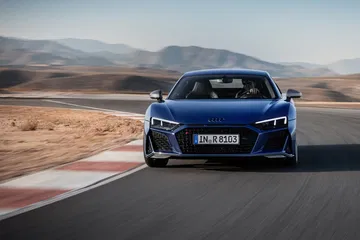 Vista delantera del Audi R8 en plena aceleración sobre asfalto de circuito.