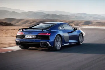 El Audi R8 muestra su perfil y trasera deportivos, destacando su diseño aerodinámico.