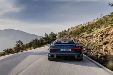 Vista trasera del Audi R8 dominando la carretera, destacando su diseño y escape.