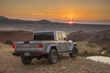 Vista lateral y trasera del Jeep Gladiator al atardecer en terreno desértico.
