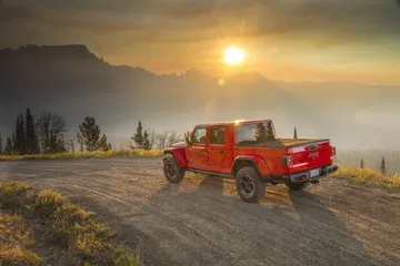 Vista del Jeep Gladiator en entorno montañoso con la luz del atardecer.