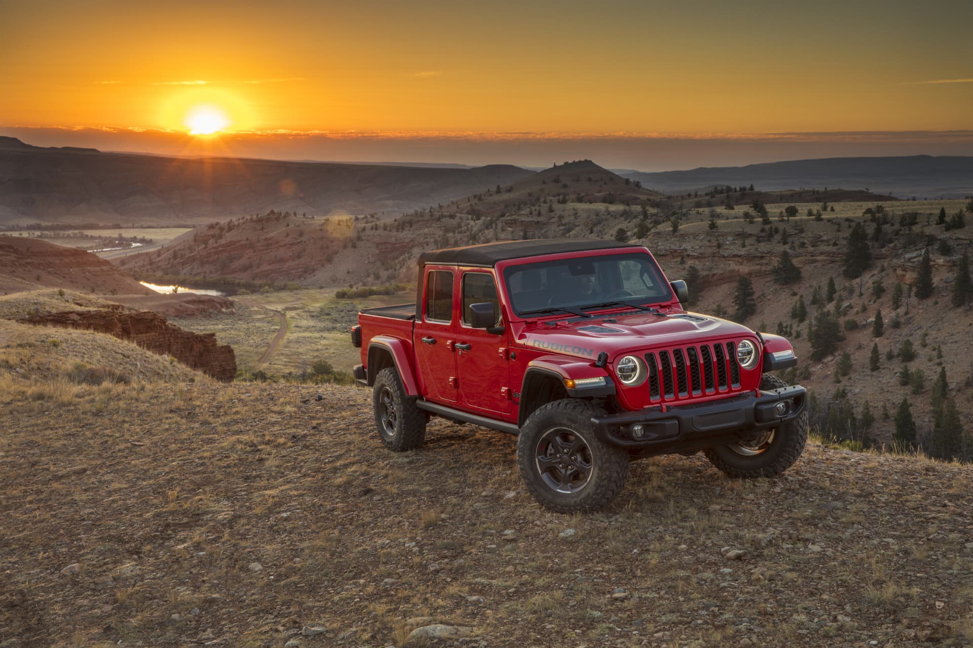 Jeep Gladiator en una ruta montañosa al atardecer, mostrando su perfil lateral.