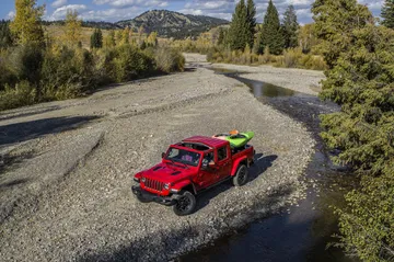 Vista lateral del Jeep Gladiator en un entorno off-road, mostrando su capacidad todoterreno.
