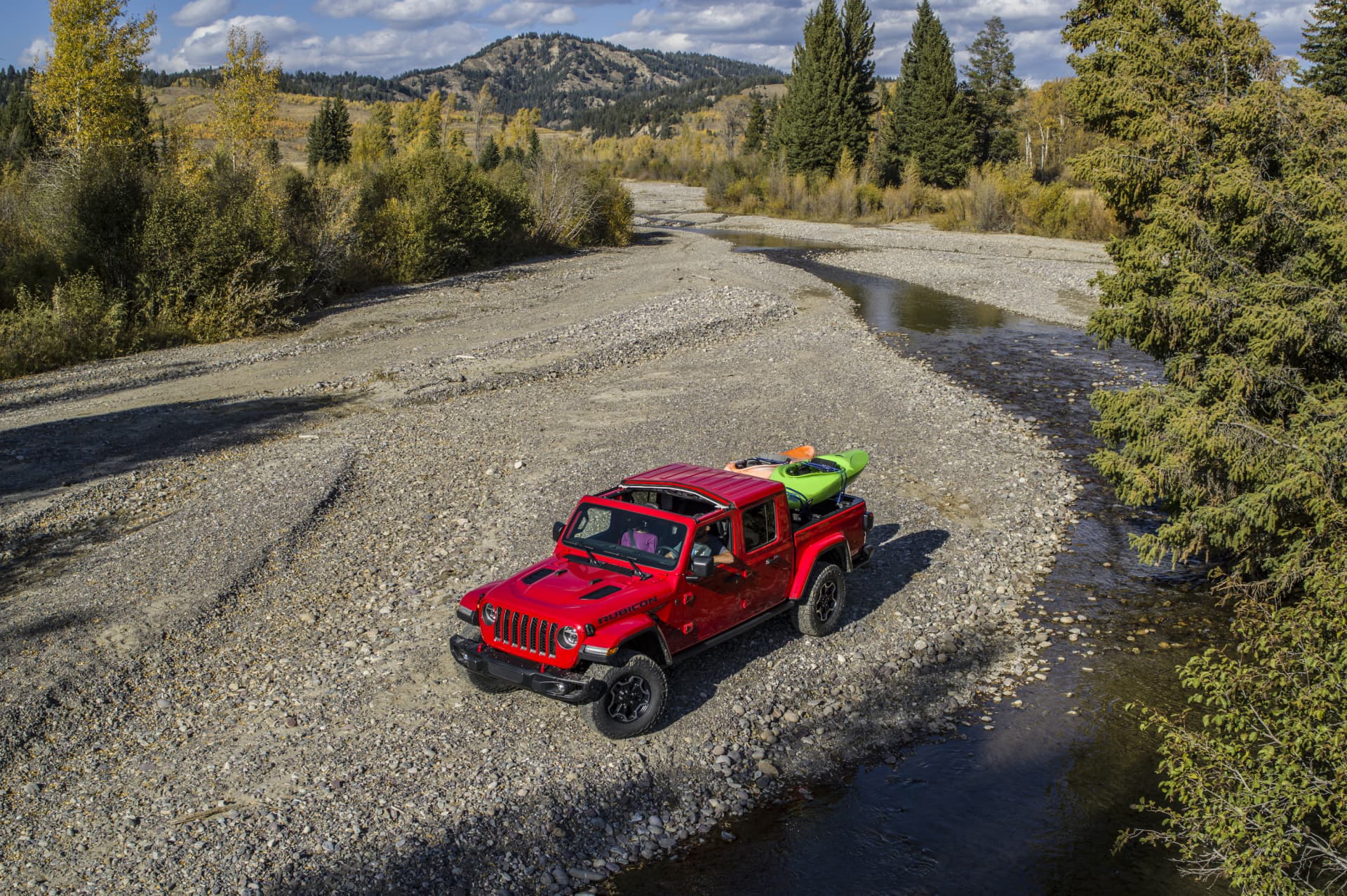 Vista lateral del Jeep Gladiator en un entorno off-road, mostrando su capacidad todoterreno.