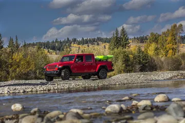 Vista lateral del Jeep Gladiator cruzando un río, mostrando su capacidad todoterreno.