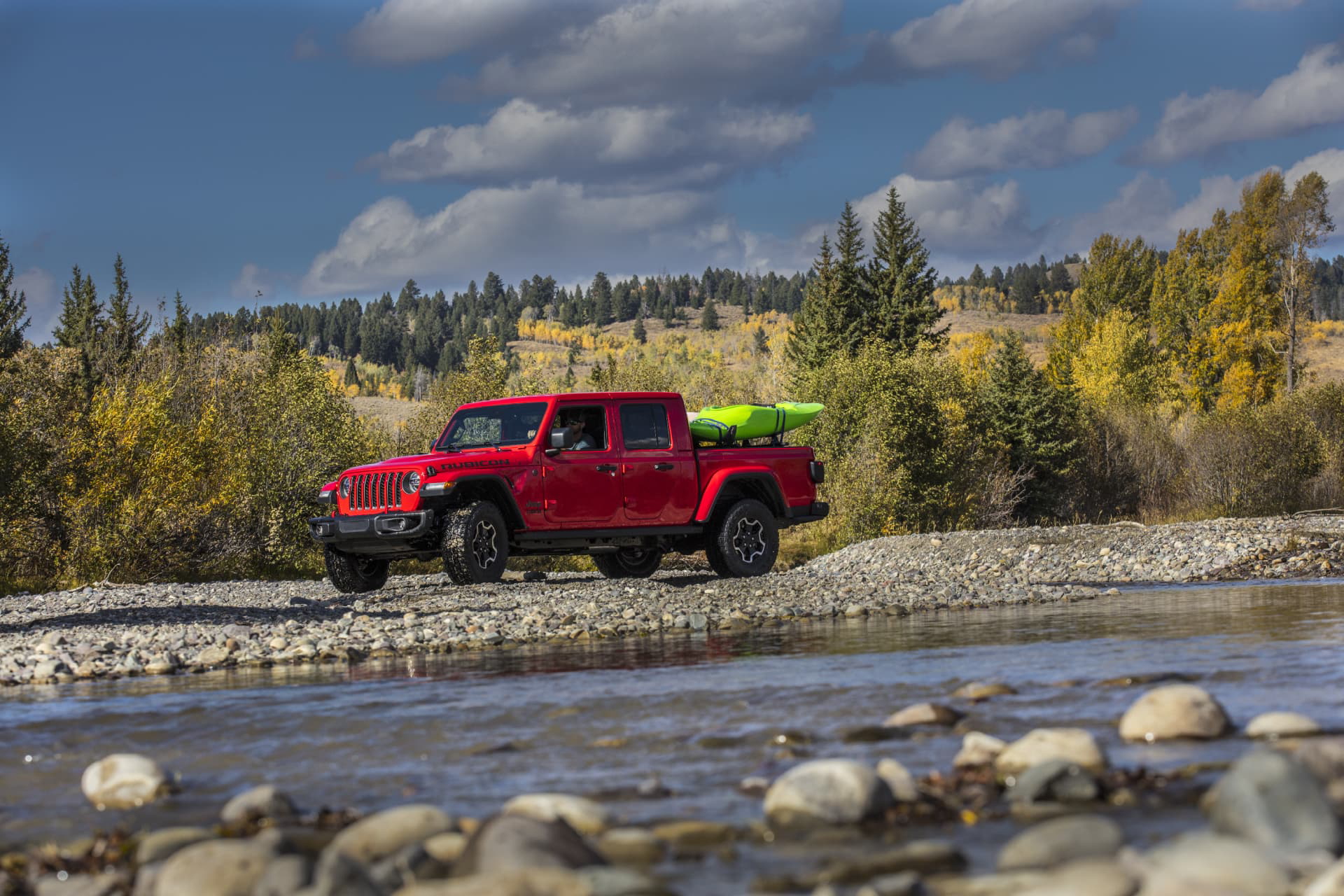 Vista lateral del Jeep Gladiator cruzando un río, mostrando su capacidad todoterreno.