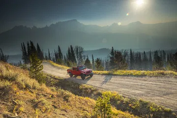 Jeep Gladiator recorriendo camino de montaña con paisaje impresionante al fondo.