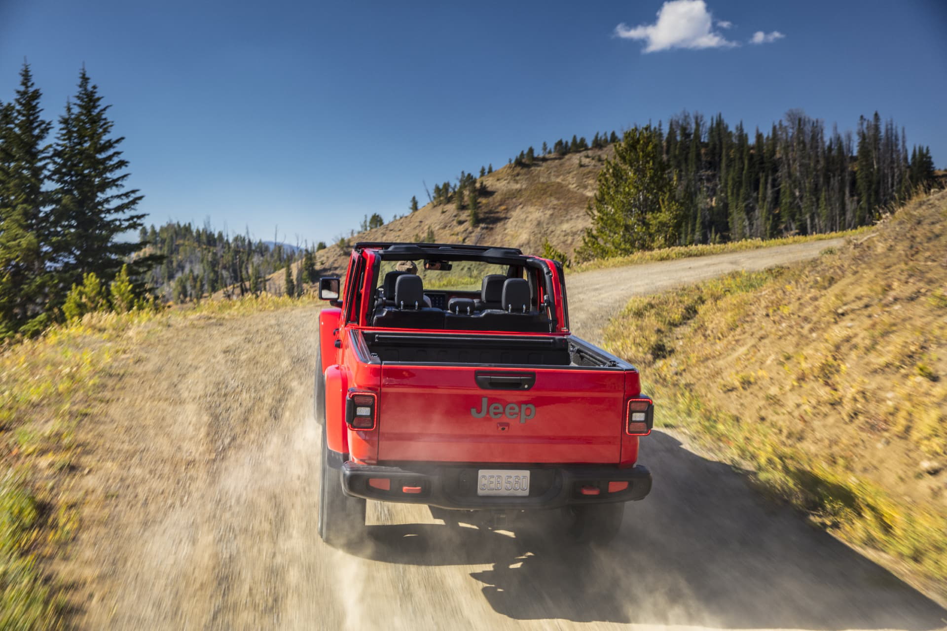 Jeep Gladiator enfrentando un camino de montaña, vista trasera y lateral.