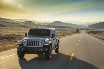 Jeep Gladiator avanzando con robustez por una carretera al amanecer.