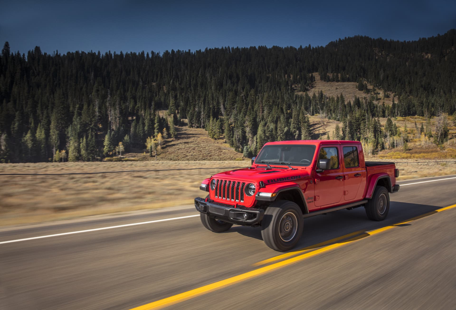 Jeep Gladiator avanzando por carretera de montaña, mostrando su perfil lateral.