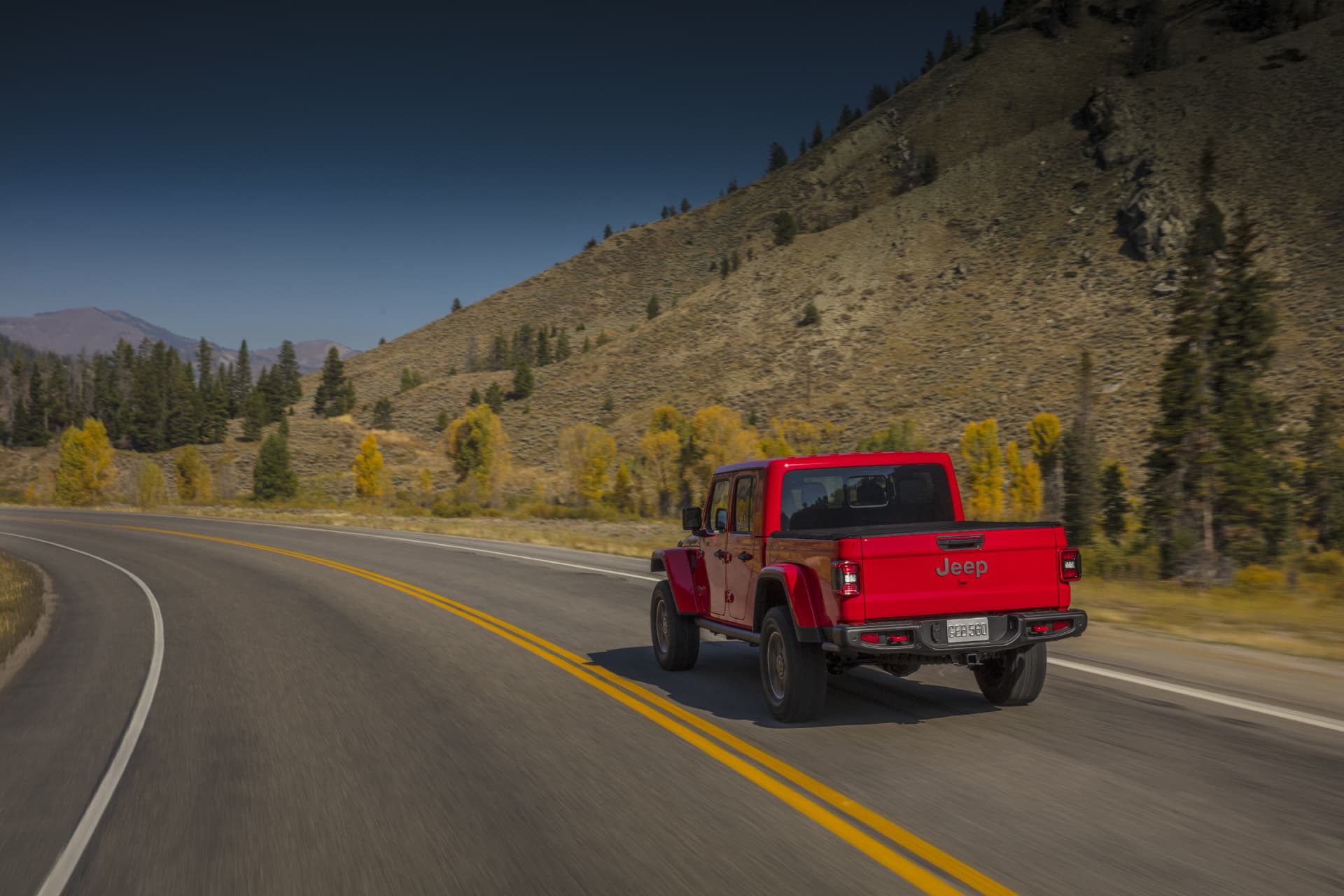 Jeep Gladiator mostrando su diseño trasero y lateral en carretera otoñal