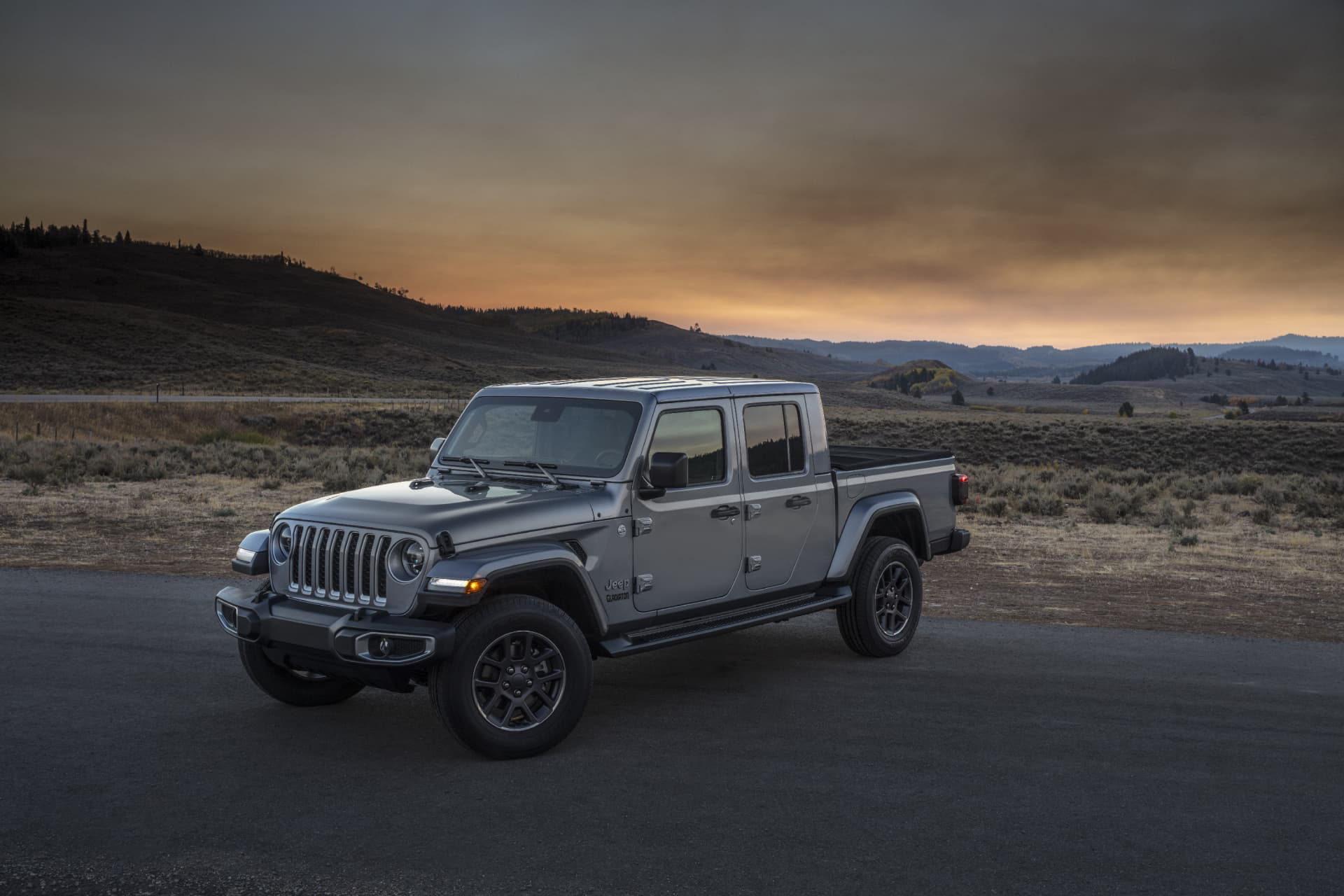 Vista lateral de un Jeep Gladiator al crepúsculo, destacando su silueta y diseño robusto.