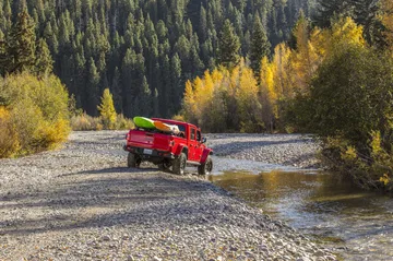 El Jeep Gladiator avanza por un terreno agreste, demostrando sus capacidades todoterreno.