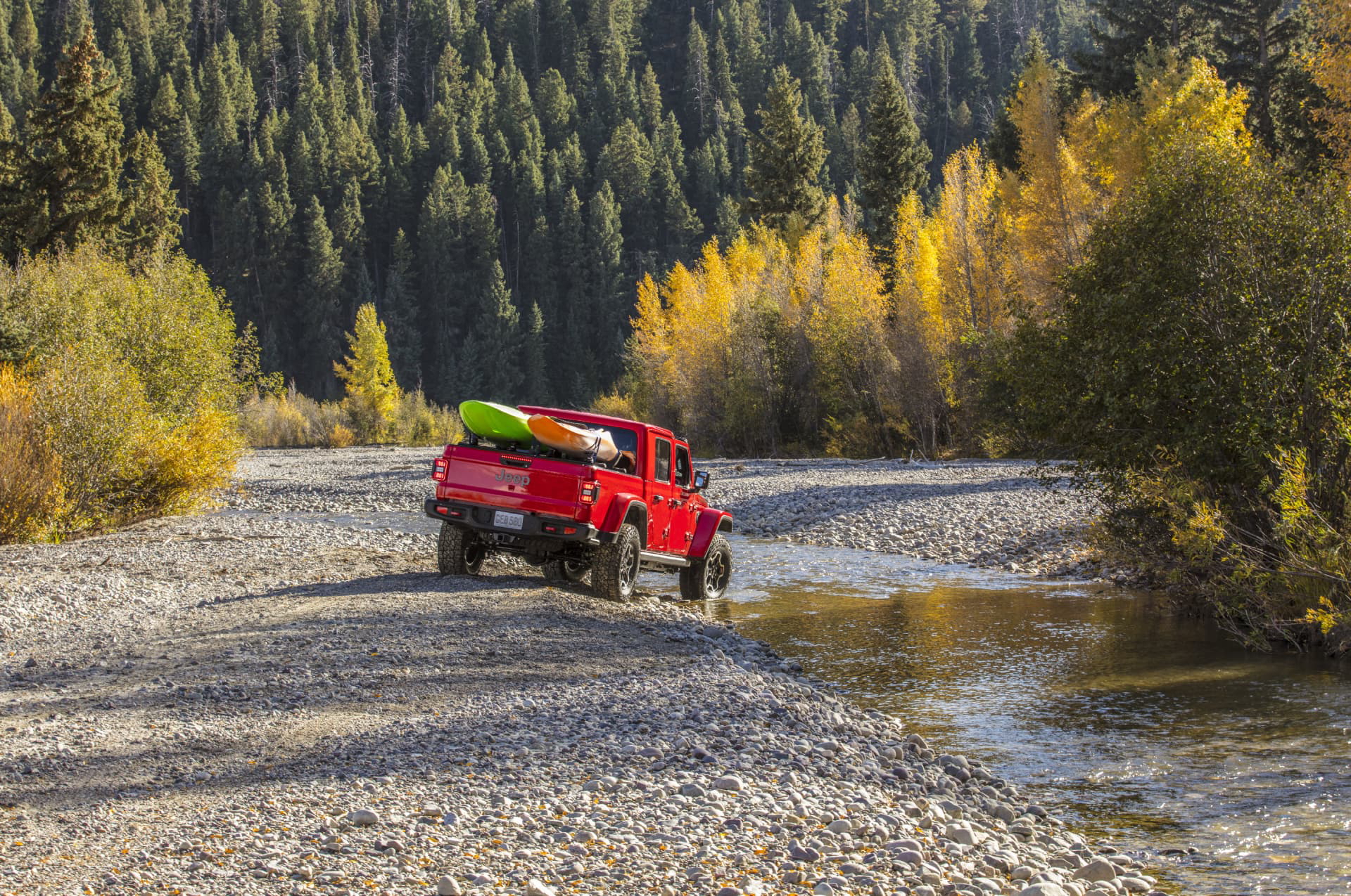 El Jeep Gladiator avanza por un terreno agreste, demostrando sus capacidades todoterreno.