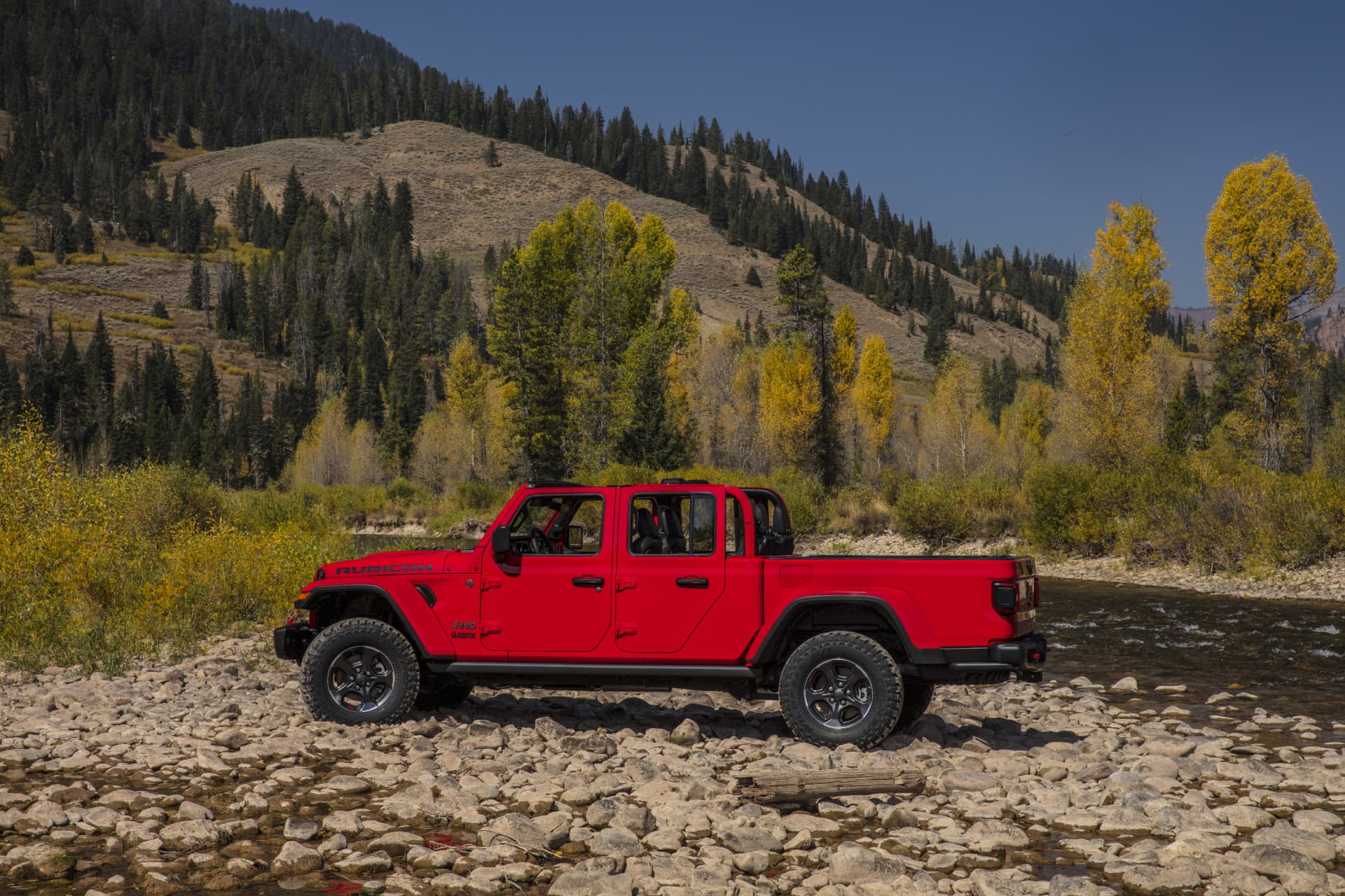 Vista lateral de un Jeep Gladiator en entorno montañoso, evocando robustez y aventura.