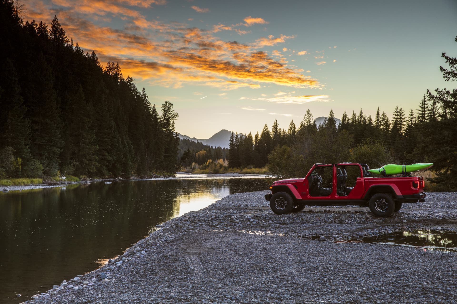 Jeep Gladiator aparcado al lado de un lago, mostrando su perfil lateral y capacidades off-road.