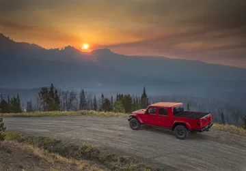 Jeep Gladiator captado desde un ángulo lateral con un atardecer de fondo.