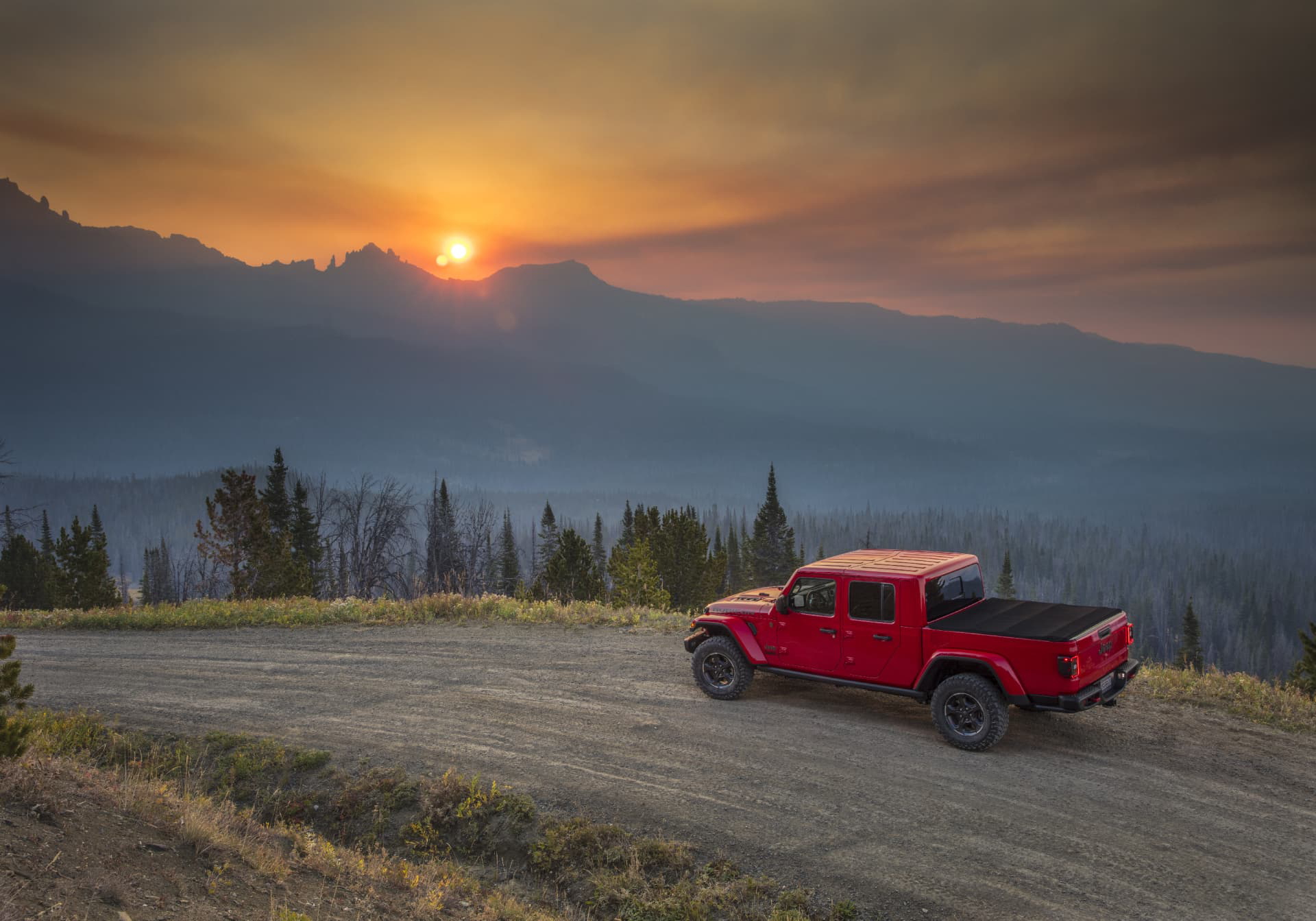 Jeep Gladiator captado desde un ángulo lateral con un atardecer de fondo.