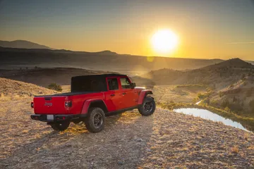 Jeep Gladiator capturado en un atardecer dorado, resaltando su perfil robusto.