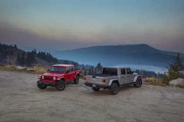 Vista lateral del Jeep Gladiator en un escenario de montaña al atardecer