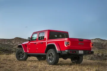 Vista lateral del Jeep Gladiator en color rojo destacando su diseño robusto.
