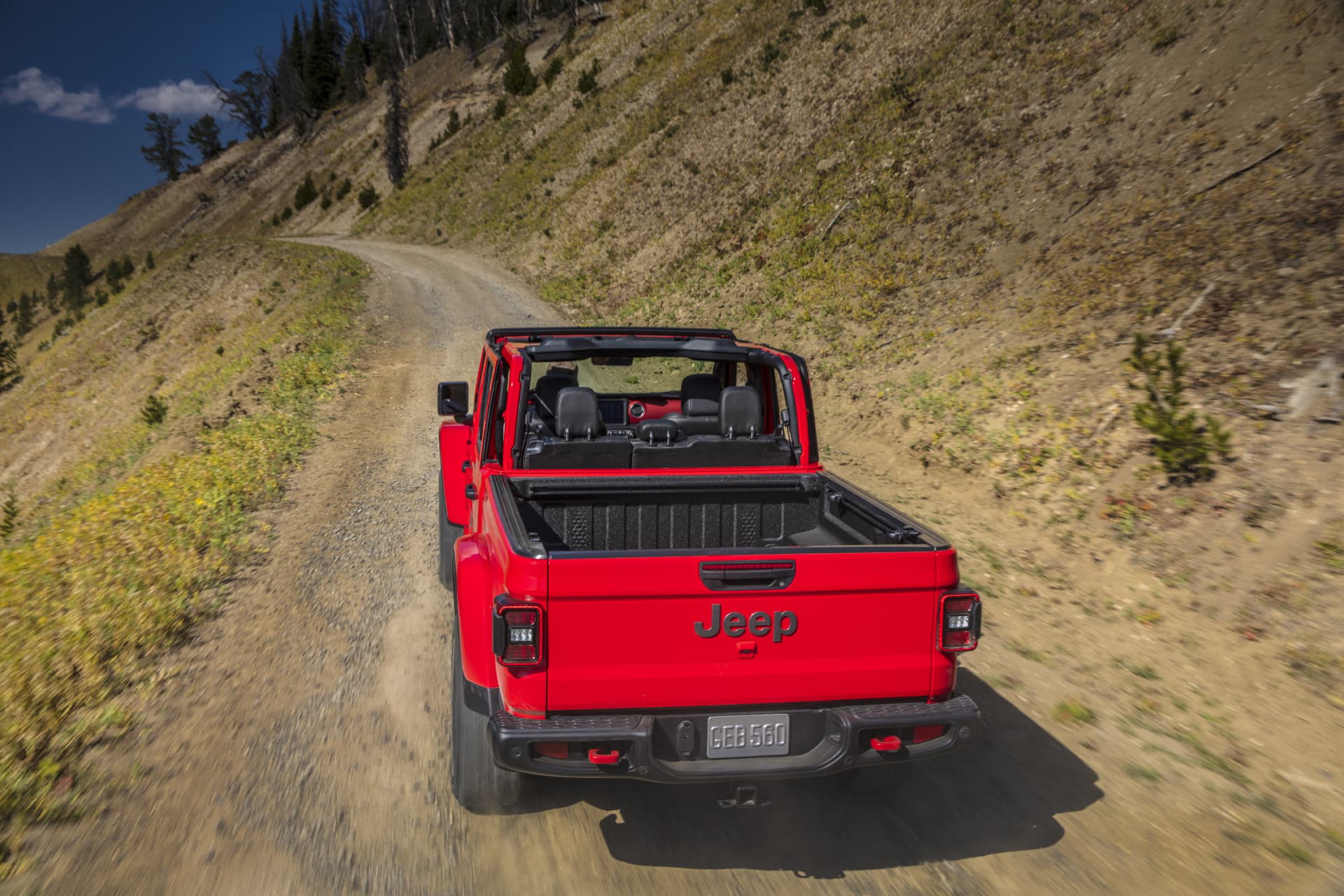 Vista aérea de un Jeep Gladiator rojo en una carretera de montaña