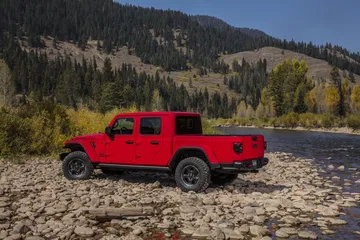 Vista lateral del Jeep Gladiator en color rojo, destacando su diseño aventurero.