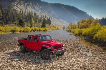 Vista lateral del Jeep Gladiator en un entorno natural, destacando su perfil robusto.