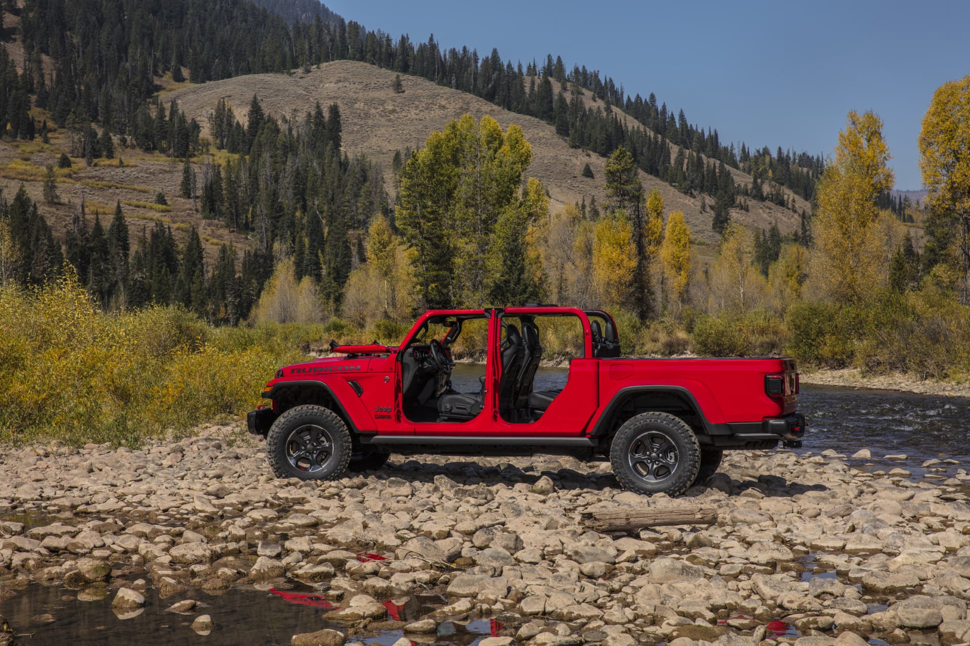 Imponente Jeep Gladiator en tono rojo destacando en un entorno natural
