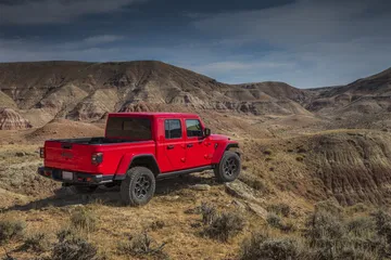 Jeep Gladiator rojo dominando terreno accidentado con notables capacidades off-road.