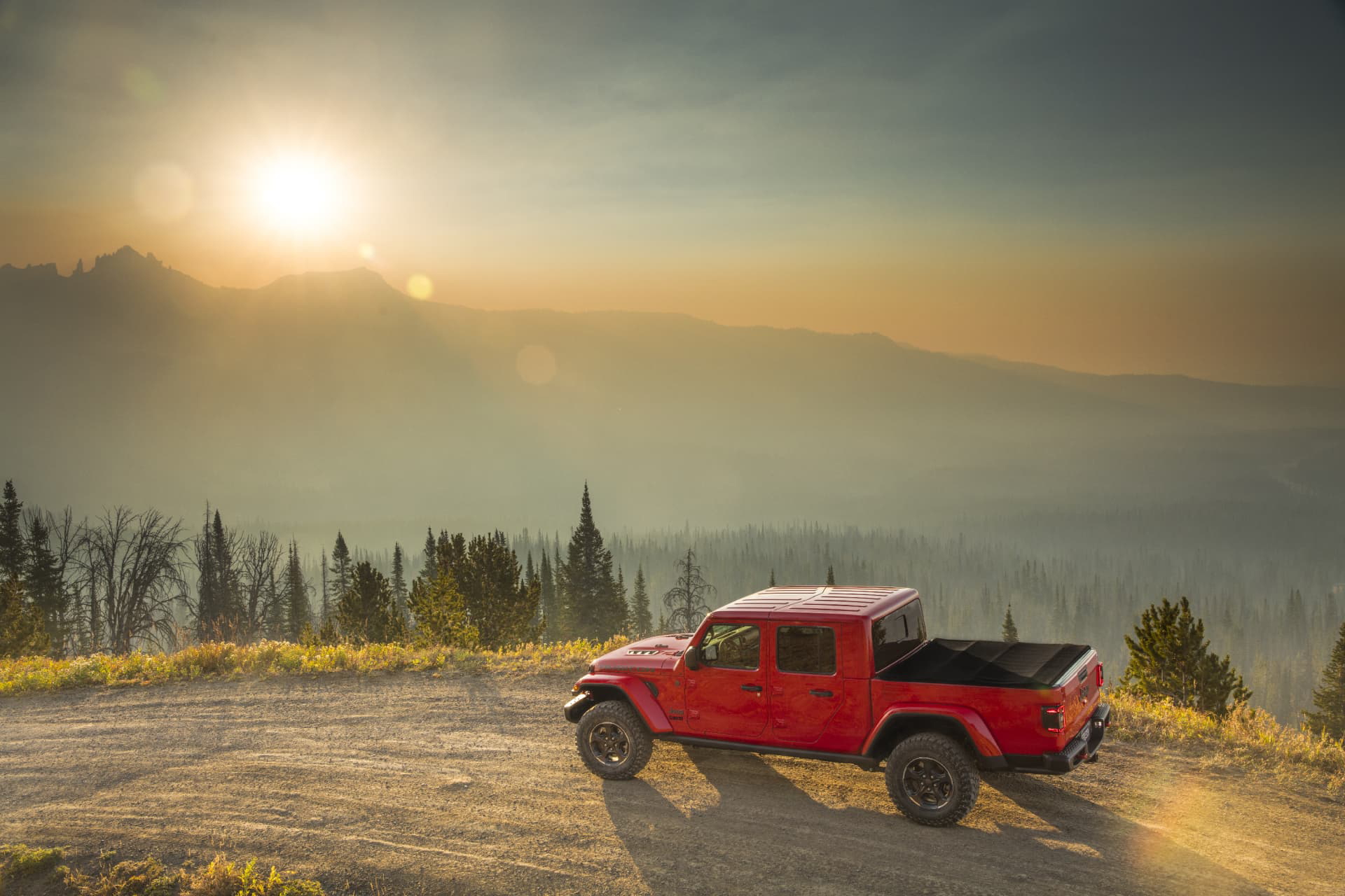 Jeep Gladiator rojo destacando su capacidad todoterreno al atardecer.