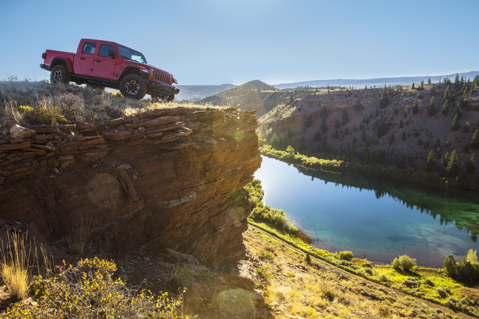 Jeep Gladiator en acción sobre un acantilado, demostrando sus capacidades off-road.