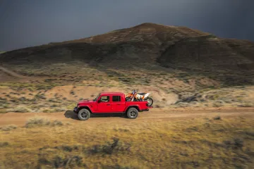 Jeep Gladiator avanzando con firmeza por terreno irregular.