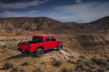 Vista lateral del Jeep Gladiator superando terreno accidentado.
