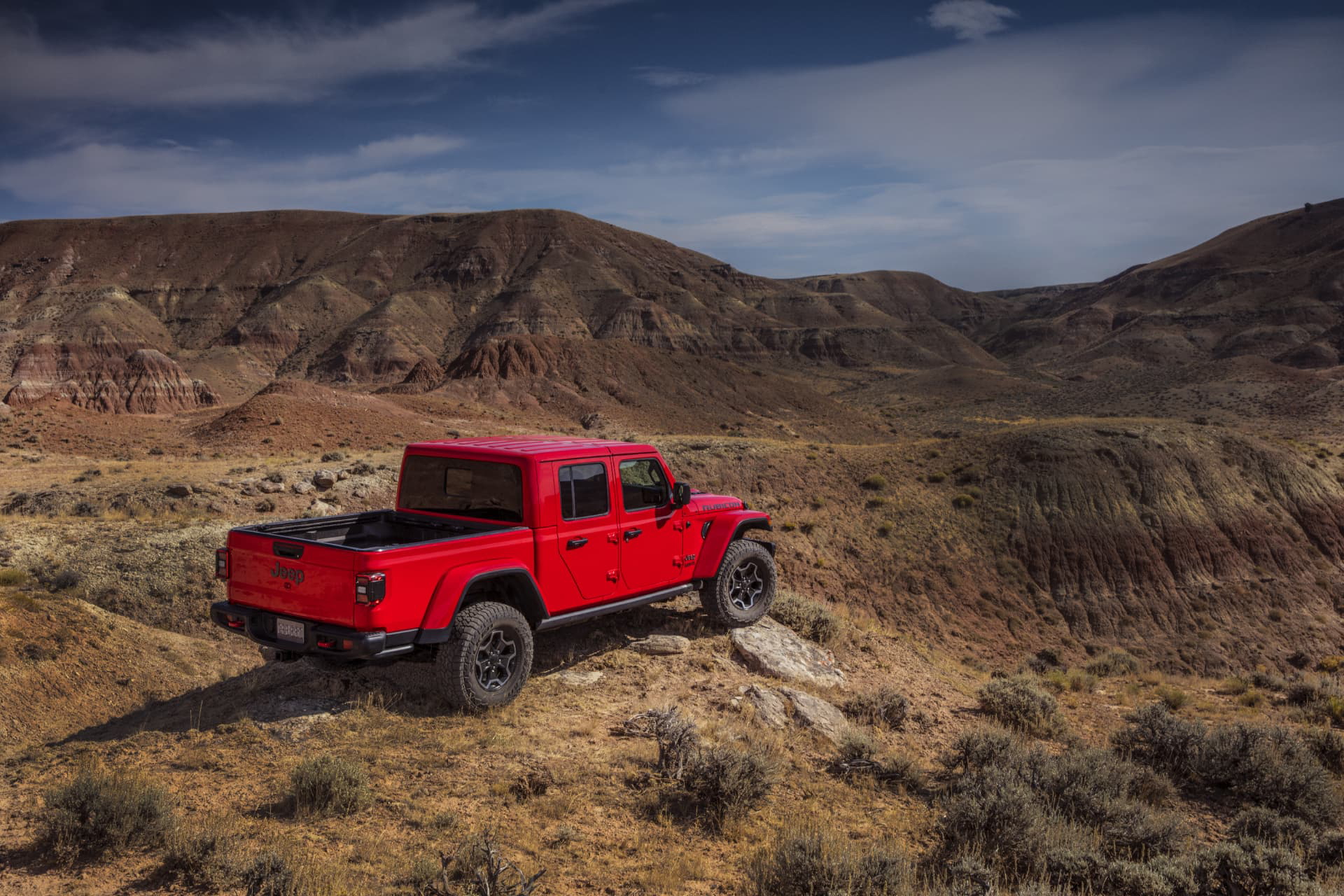 Vista lateral del Jeep Gladiator superando terreno accidentado.
