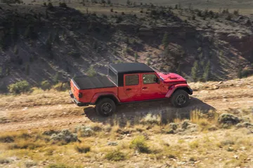 Jeep Gladiator mostrando su capacidad todoterreno en una pendiente rocosa.