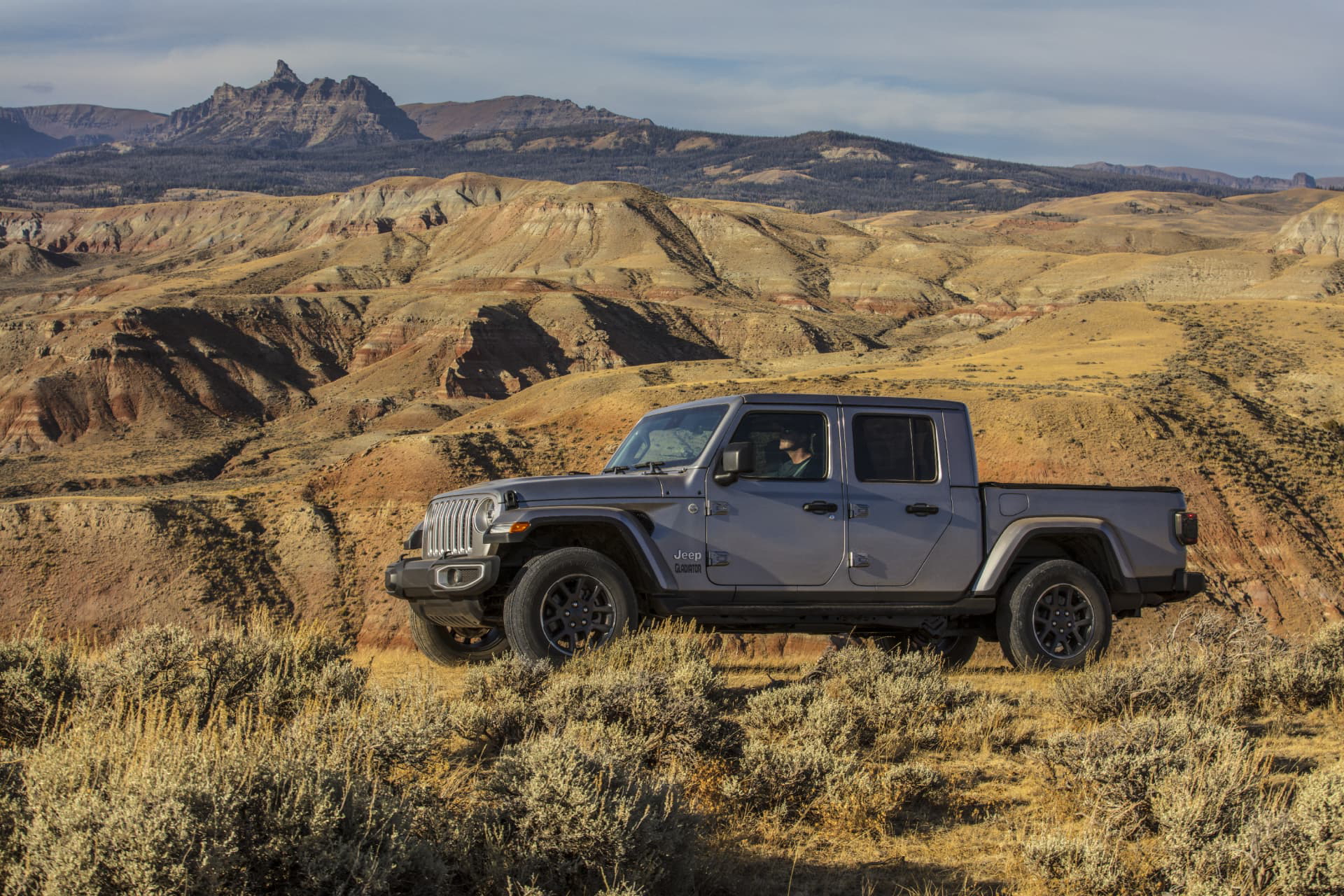 Vista lateral del Jeep Gladiator superando terreno accidentado, mostrando su capacidad off-road.