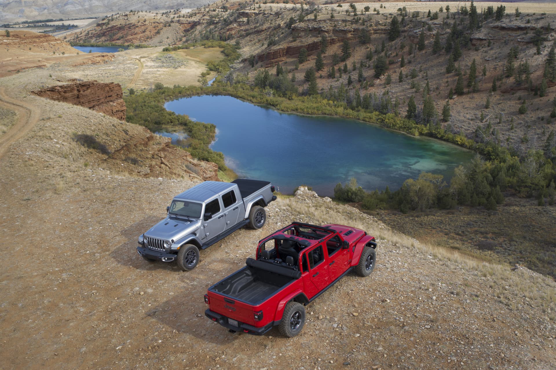 Vista lateral de dos Jeep Gladiator en terreno natural, mostrando robustez y versatilidad