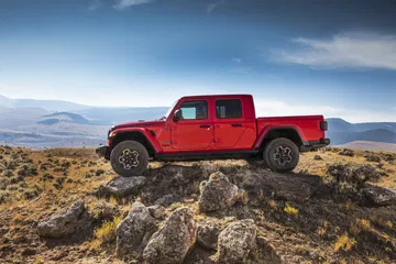 Vista lateral del Jeep Gladiator superando terreno rocoso con habilidad