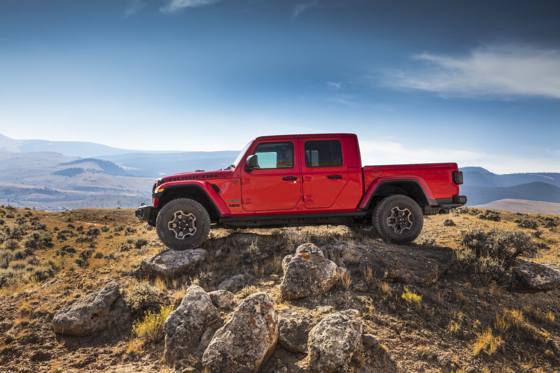 Vista lateral del Jeep Gladiator superando terreno rocoso con habilidad